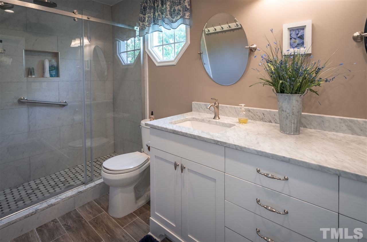 4017 Forty-Niner's Road Clayton, NC 27520 - Photo 14 of 25 Bathroom is Updated with Custom Cabinet, Dual Vanity, Oversized Shower and Walk-in Closet