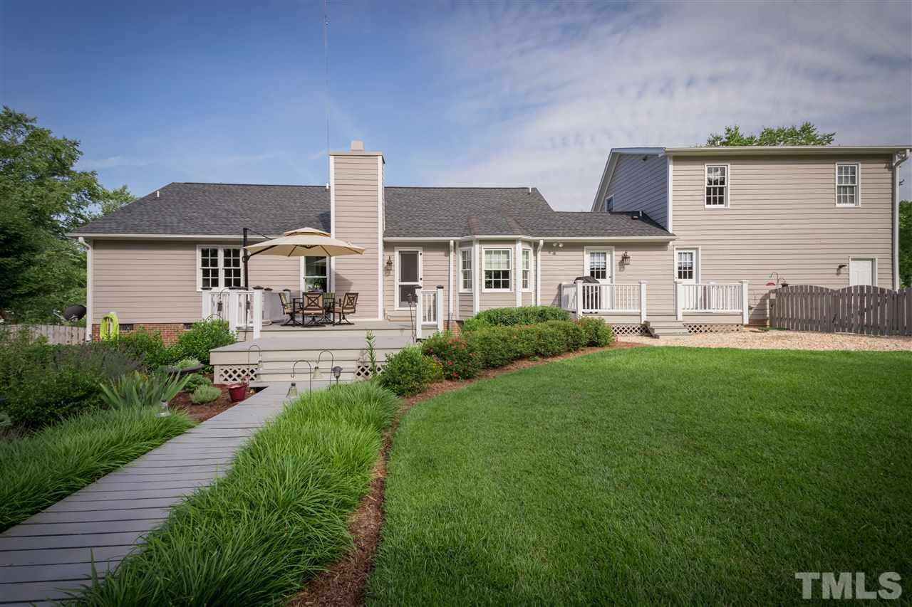4017 Forty-Niner's Road Clayton, NC 27520 - Photo 22 of 25 View of the Exterior House and Backyard with Boardwalk Leading from Deck to Firepit Area