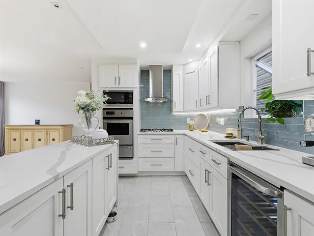 a kitchen with white cabinets and appliances