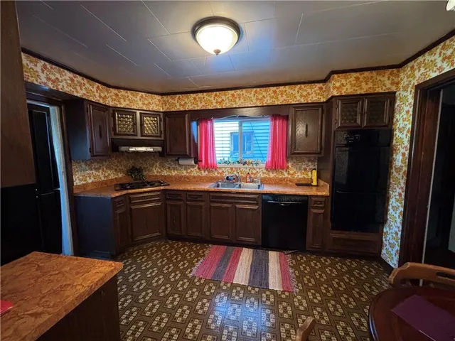 a kitchen with stainless steel appliances kitchen island granite countertop a refrigerator stove top oven and sink