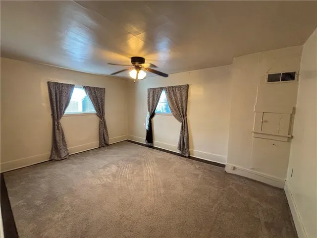 an empty room with a ceiling fan and a window