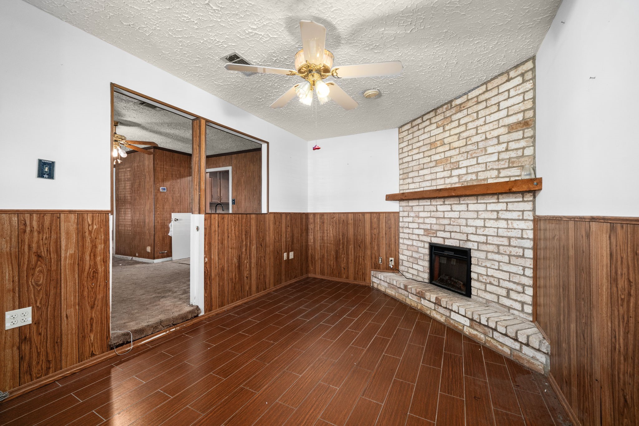 56 Wellford Street Houston, TX 77022 - Photo 7 of 26 a view of an empty room with wooden floor a fireplace and a window