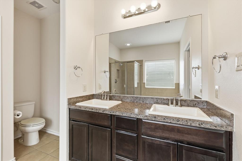 720 Rio Bravo Drive Fort Worth, TX 76052 - Photo 25 of 38 Dual vanity with dark wood-finish cabinetry and light-toned stone countertops