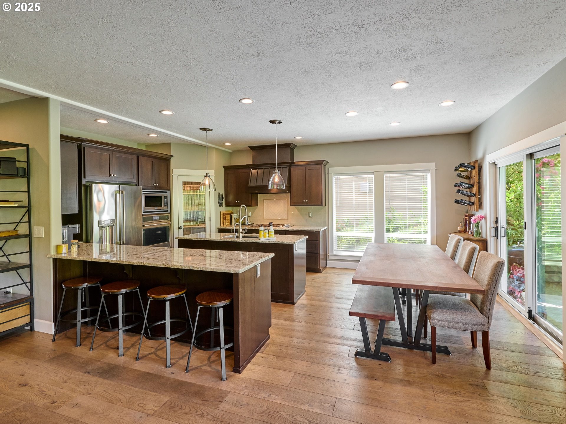 3035 Elliot Street Northwest Salem, OR 97304 - Photo 11 of 46 a kitchen with kitchen island granite countertop a table chairs sink and wooden floor