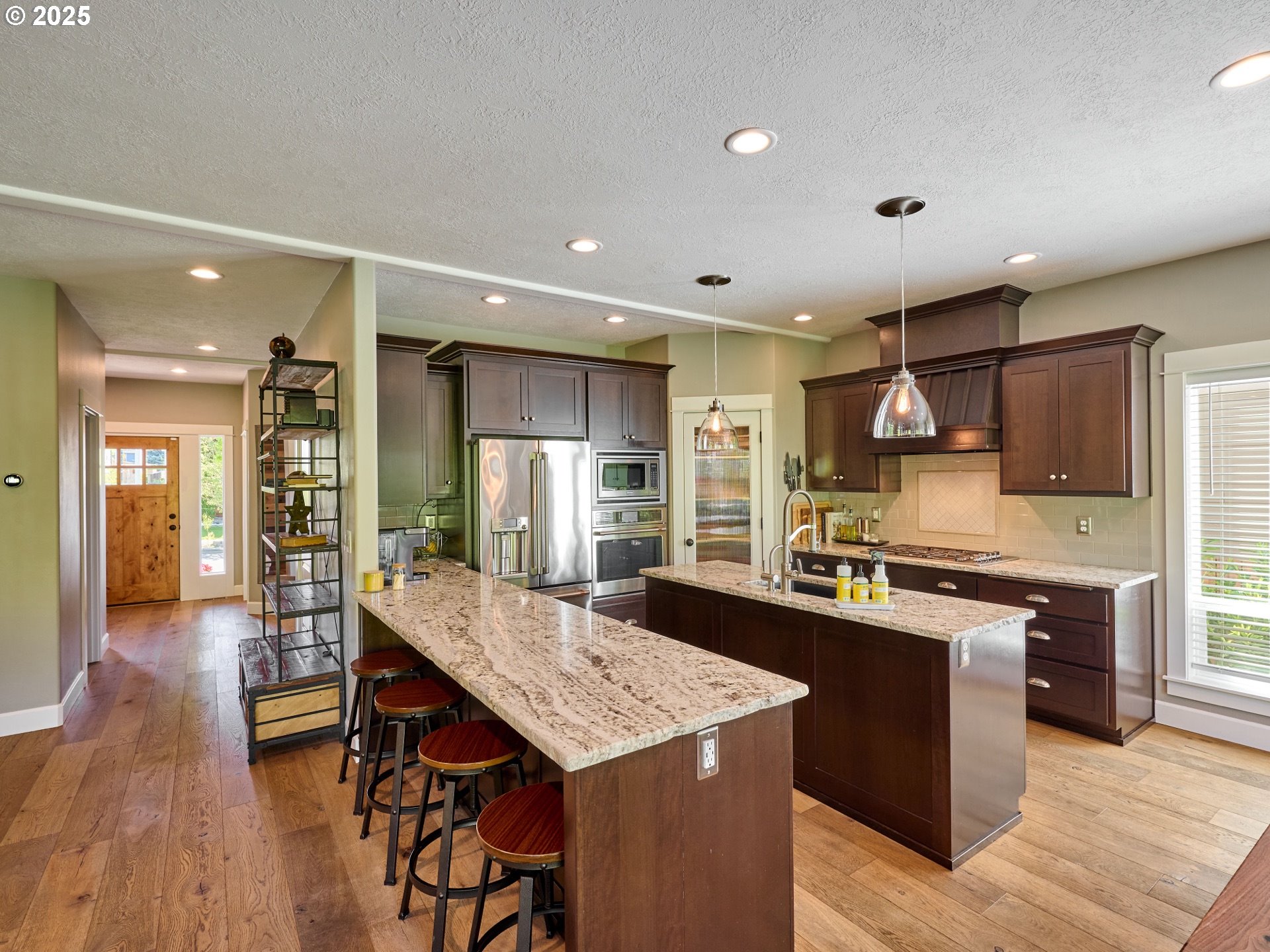 3035 Elliot Street Northwest Salem, OR 97304 - Photo 13 of 46 a large kitchen with kitchen island a stove a sink a refrigerator and wooden floor