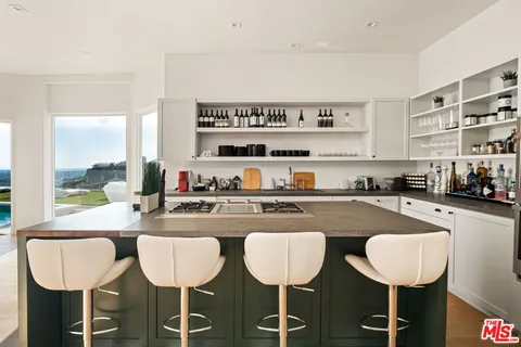 a kitchen with a dining table chairs and view living room