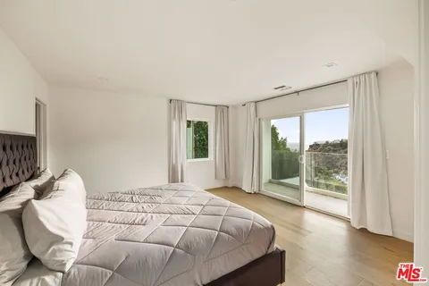a bedroom with a bed and glass window