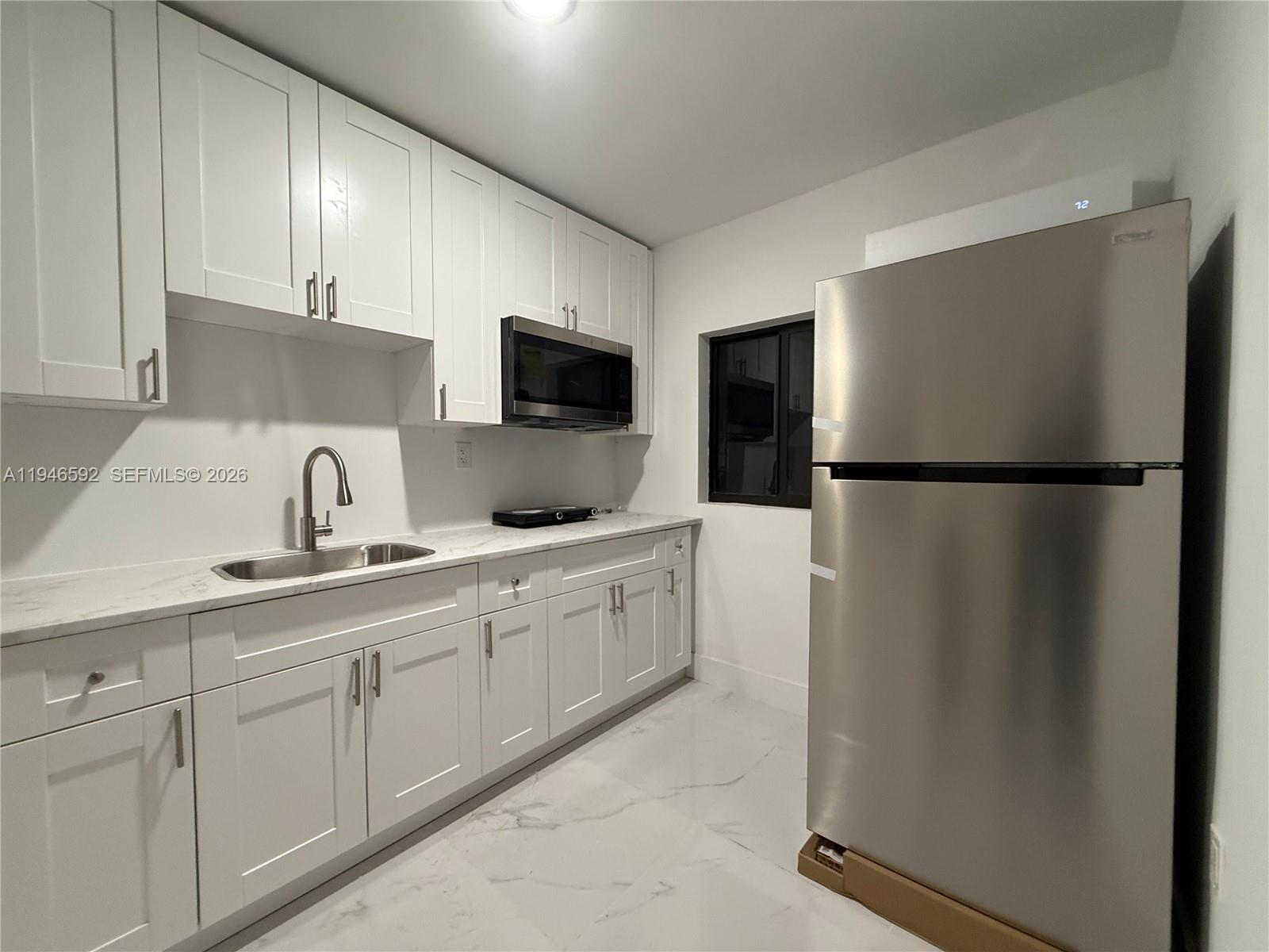 a kitchen with a refrigerator and a sink