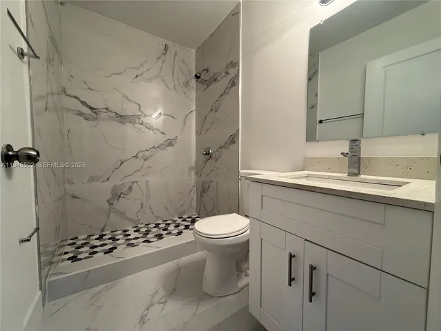 a bathroom with a sink toilet and shower