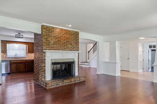a living room with a fireplace and wooden floor