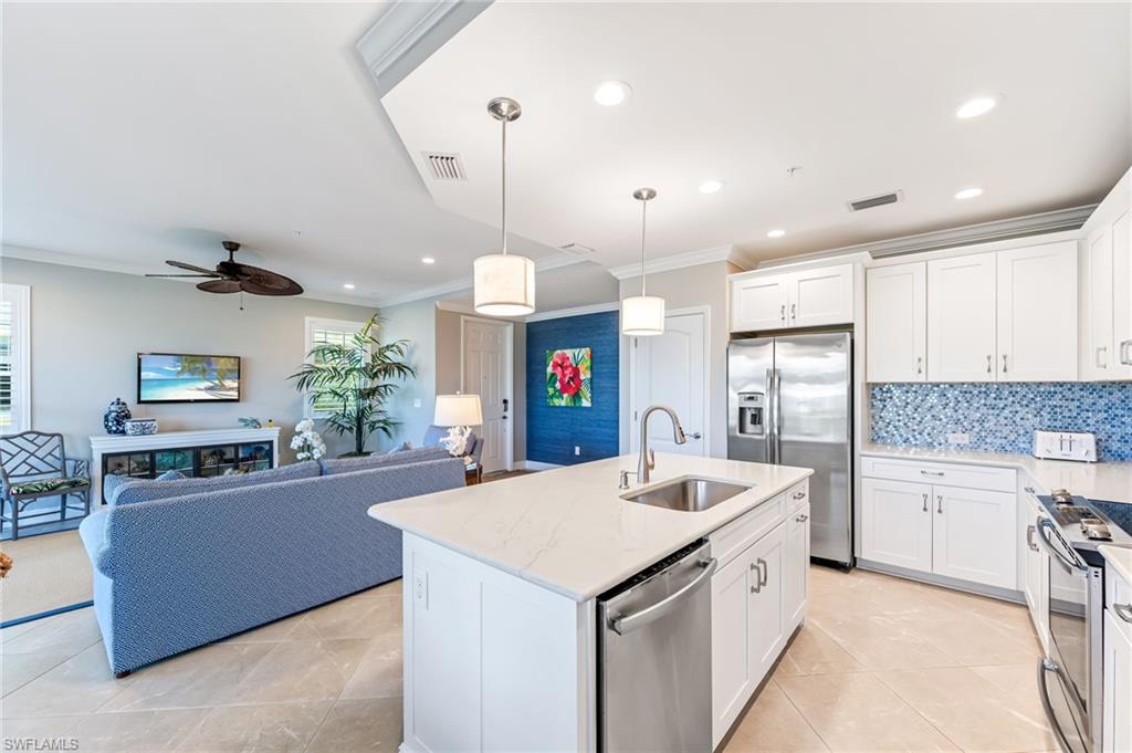 6948 Avalon Circle, Unit 604 Naples, FL 34112 - Photo 11 of 33 Kitchen featuring a sink, appliances with stainless steel finishes, crown molding, and a healthy amount of sunlight