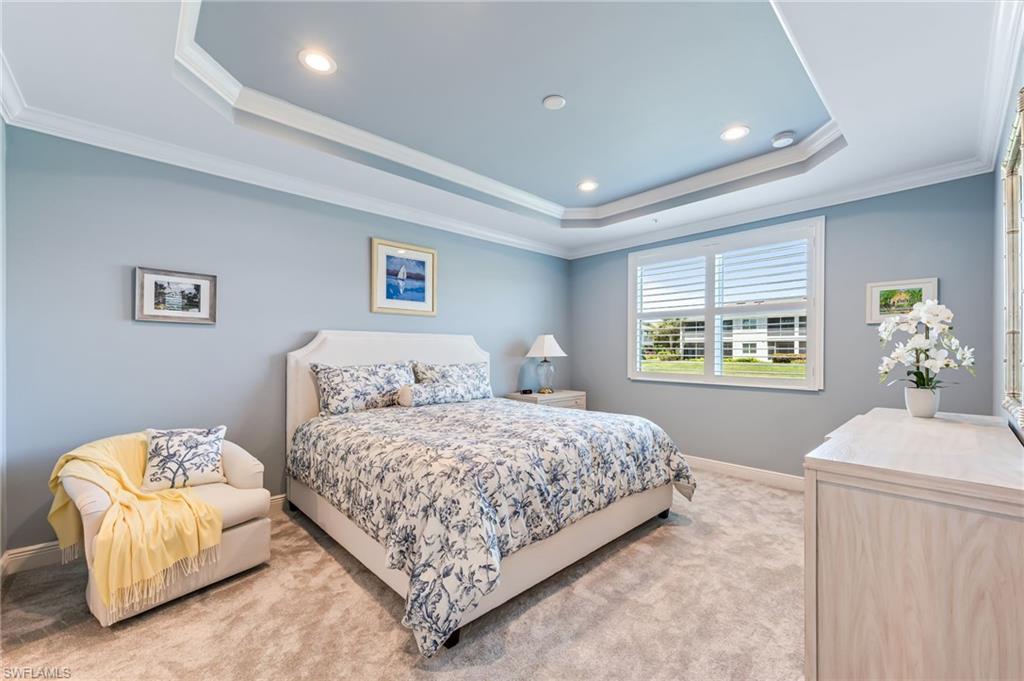 6948 Avalon Circle, Unit 604 Naples, FL 34112 - Photo 15 of 33 Bedroom featuring a raised ceiling, light carpet, and crown molding