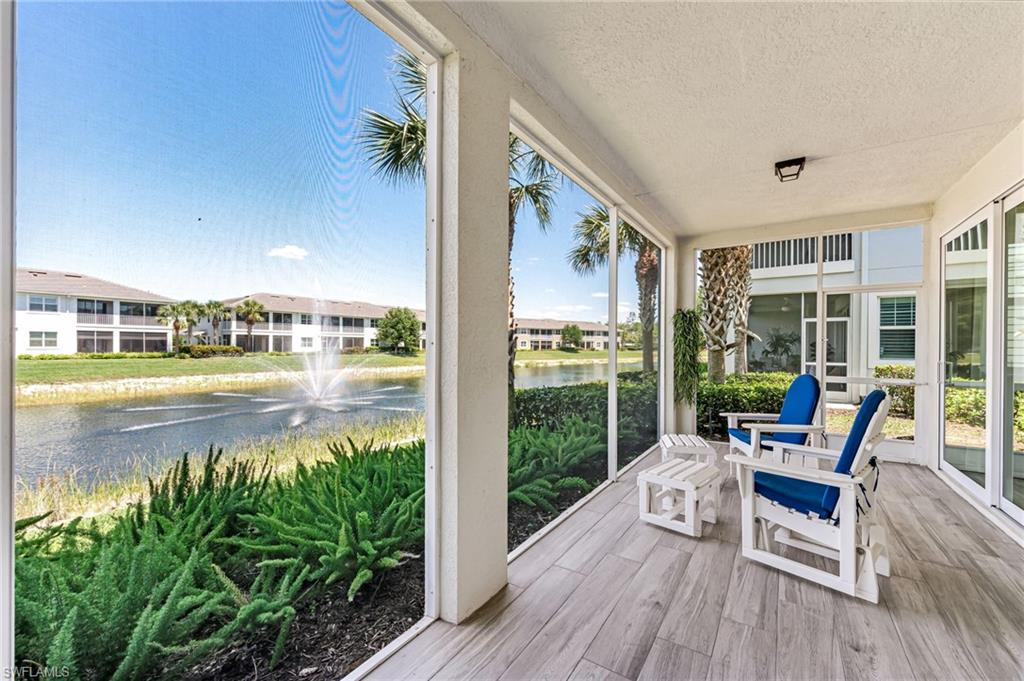 6948 Avalon Circle, Unit 604 Naples, FL 34112 - Photo 24 of 33 Sunroom / solarium featuring a textured ceiling, wood finished floors, floor to ceiling windows, and a water view
