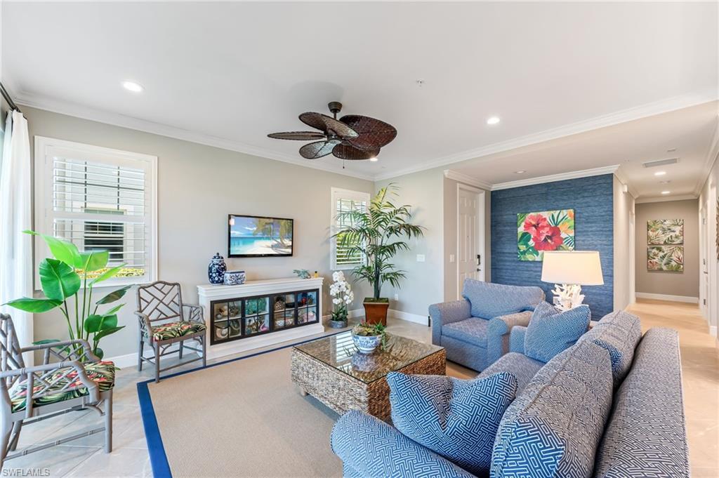 6948 Avalon Circle, Unit 604 Naples, FL 34112 - Photo 6 of 33 Living area featuring ornamental molding, ceiling fan, baseboards, and a healthy amount of sunlight