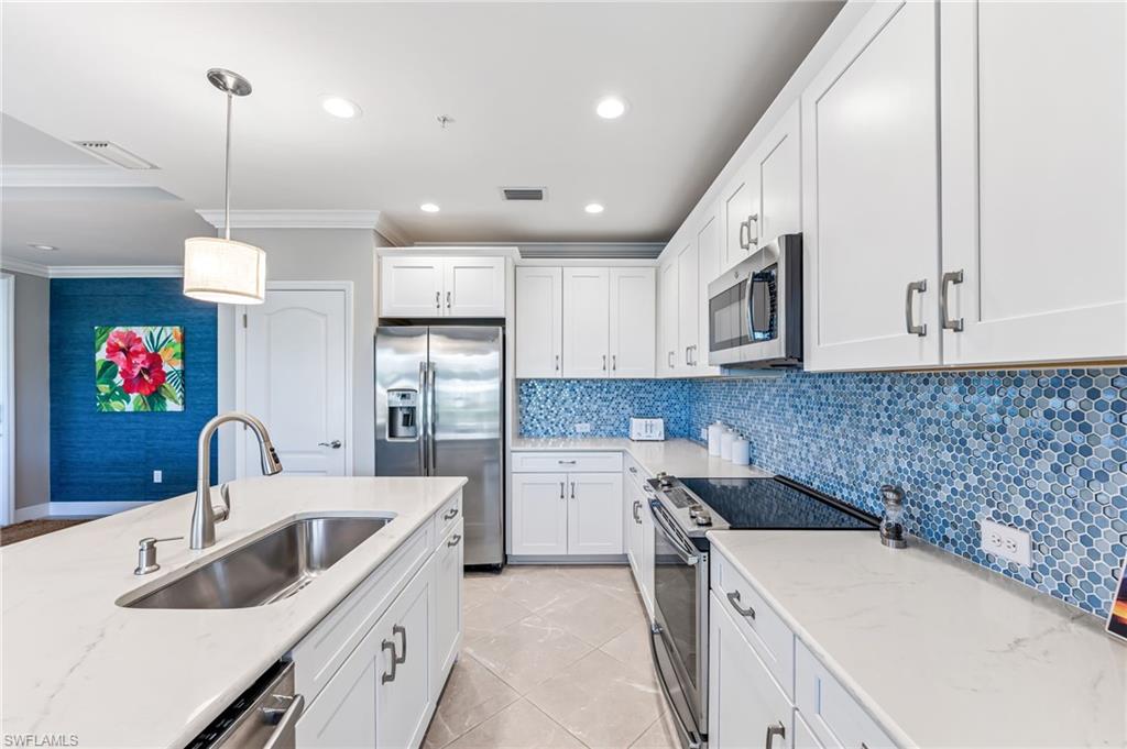 6948 Avalon Circle, Unit 604 Naples, FL 34112 - Photo 10 of 33 Kitchen with white cabinetry, ornamental molding, visible vents, appliances with stainless steel finishes, and a sink