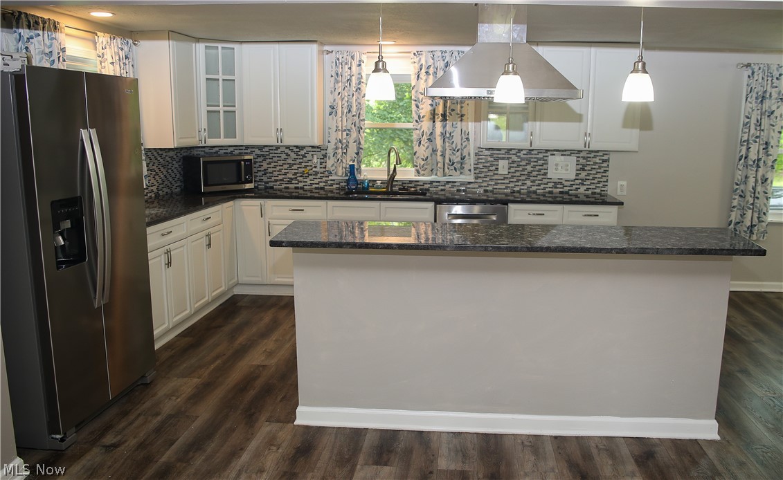1087 Krumroy Road Akron, OH 44306 - Photo 10 of 23 Kitchen featuring white cabinetry, dark stone countertops, a mosaic tile backsplash, and wood-finish flooring