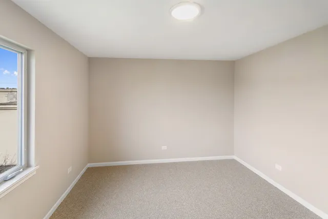 an empty room with closet and windows