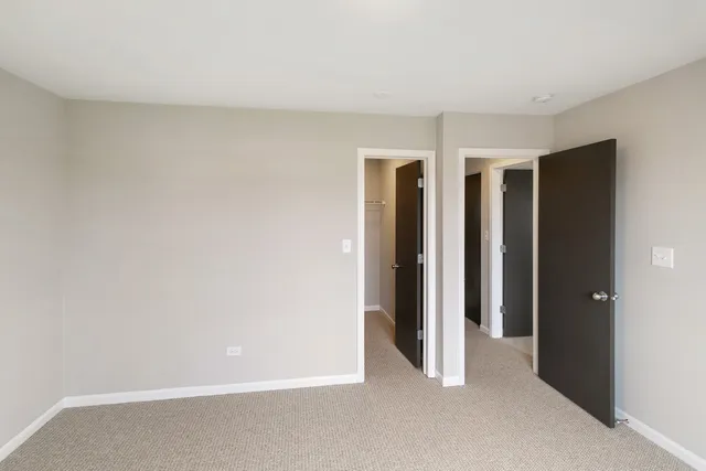 an empty room with windows and closet