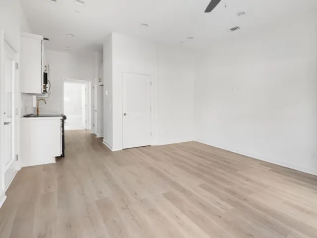 a view of a kitchen with white cabinets and a sink