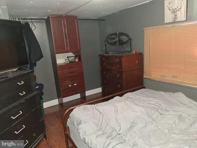 a bedroom with a bed and a flat tv screen on dresser