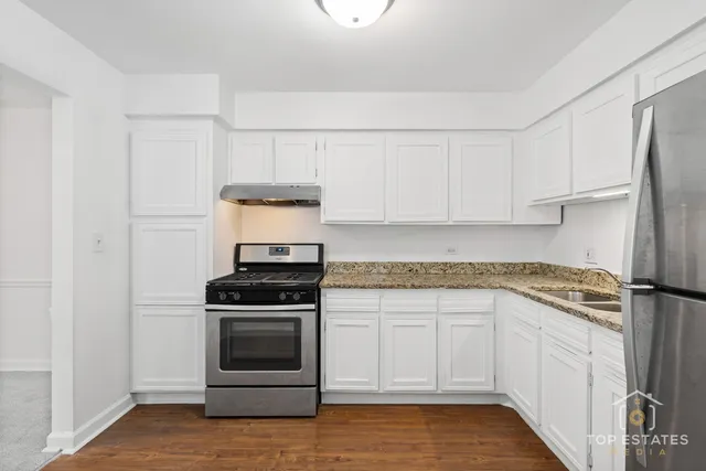 a kitchen with a stove oven and white cabinets