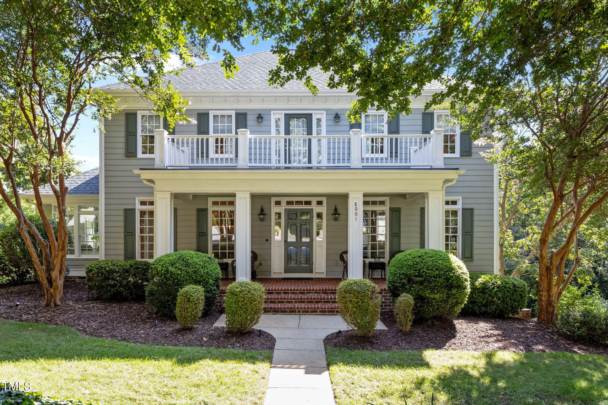 a front view of a house with yard and green space