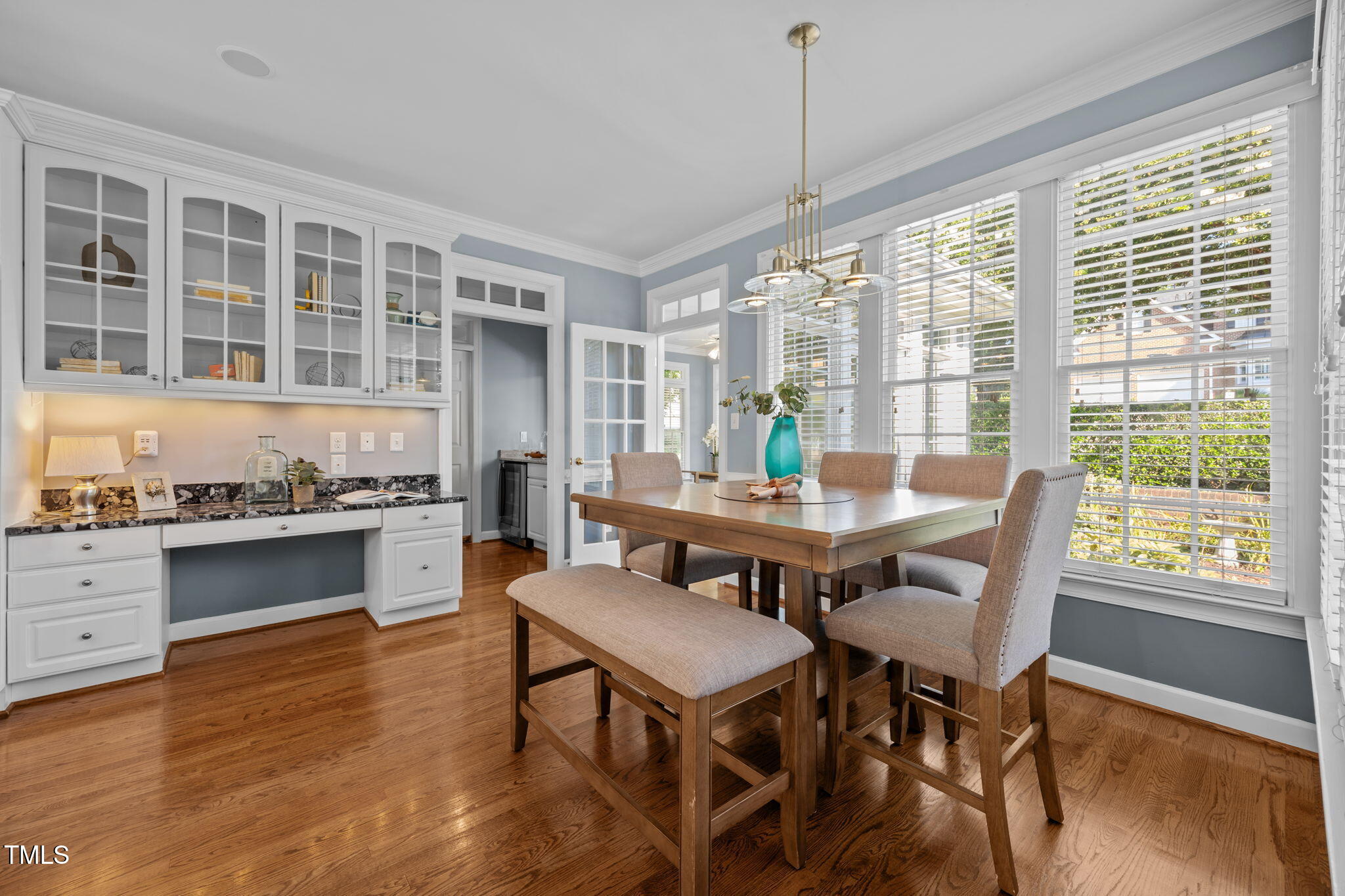 8001 Kukui Court Raleigh, NC 27613 - Photo 22 of 51 a dining room with wooden floor a chandelier a wooden table and chairs