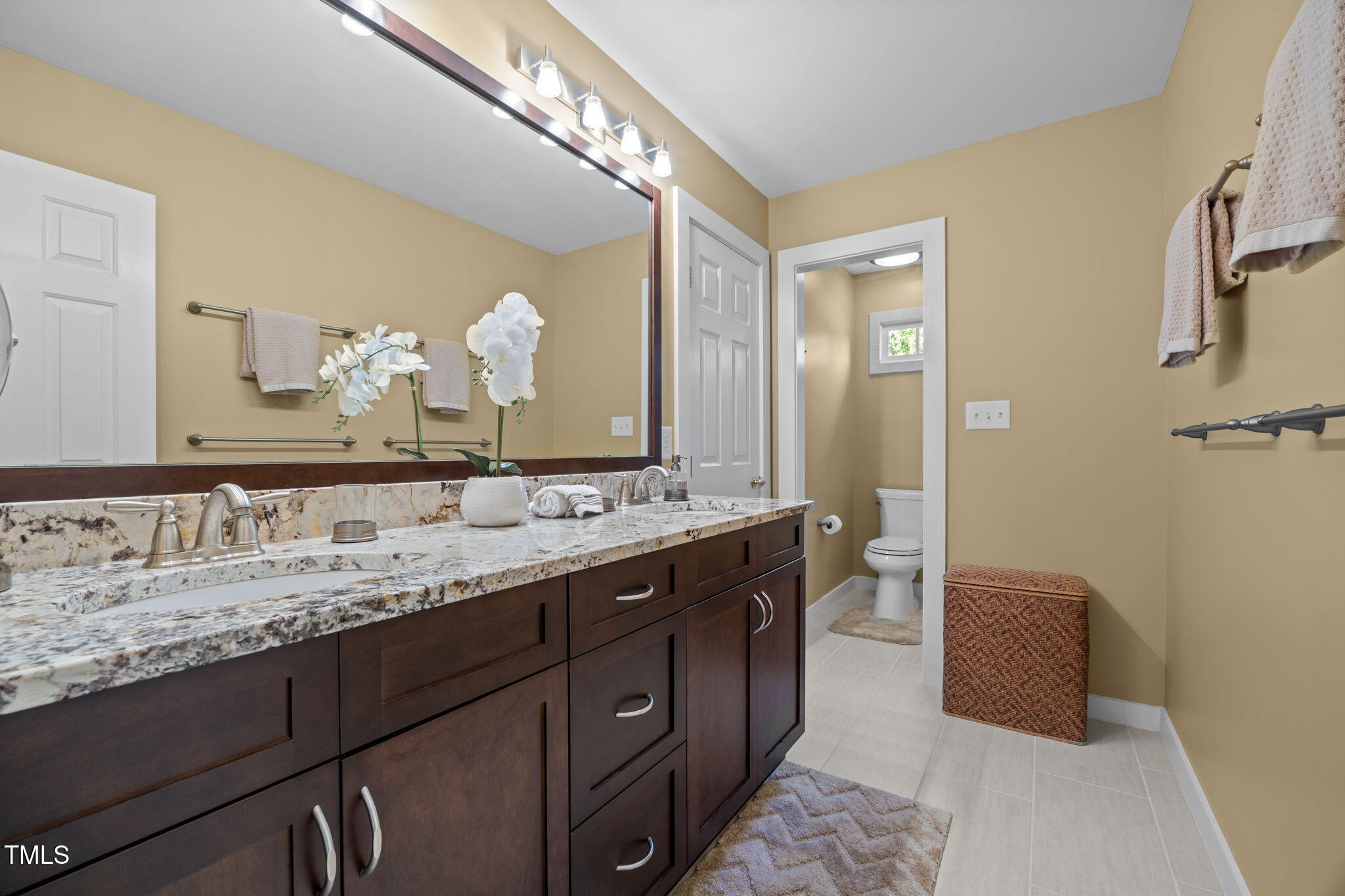 8001 Kukui Court Raleigh, NC 27613 - Photo 37 of 51 a spacious bathroom with a double vanity sink and a mirror