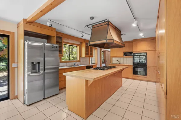 a large kitchen with stainless steel appliances kitchen island granite countertop a refrigerator and a stove