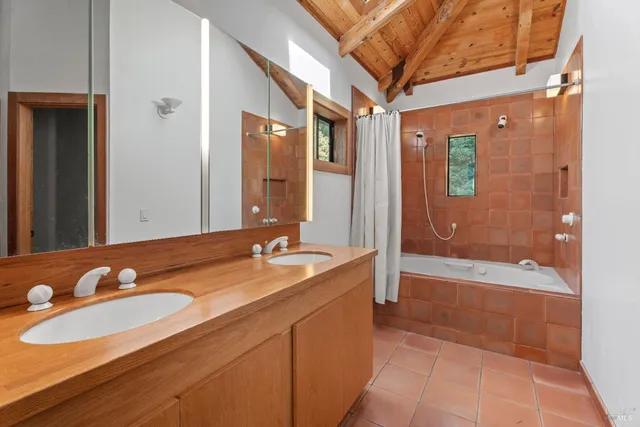 a bathroom with a granite countertop sink and a mirror a bathtub