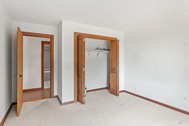 an empty room with windows and closet