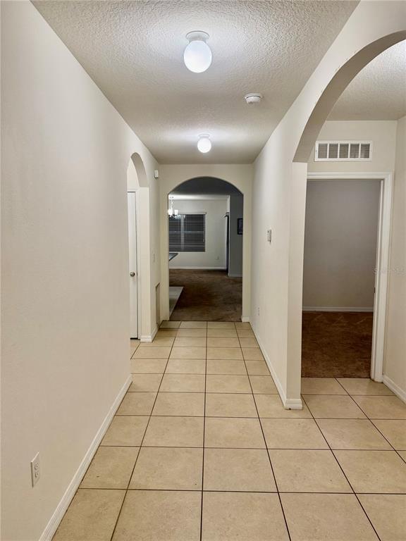1895 Hickory Bluff Road Kissimmee, FL 34744 - Photo 2 of 17 a view of a hallway with wooden floor and a living room