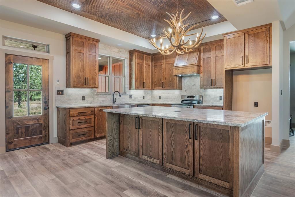 233 Jayden Lane Loving, TX 76460 - Photo 9 of 40 a bathroom with a granite countertop sink a mirror and a shower