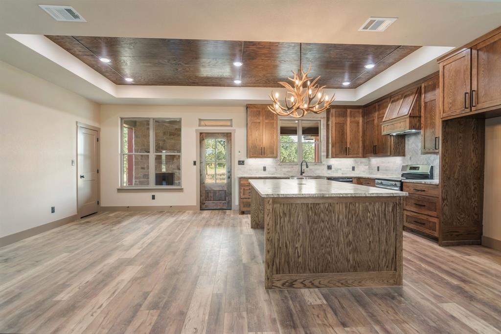 233 Jayden Lane Loving, TX 76460 - Photo 10 of 40 a large kitchen with stainless steel appliances a large counter top a stove and a refrigerator