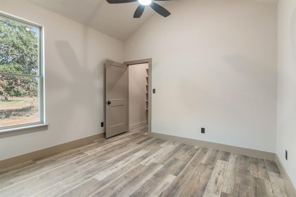 233 Jayden Lane Loving, TX 76460 - Photo 21 of 40 an empty room with windows and a ceiling fan