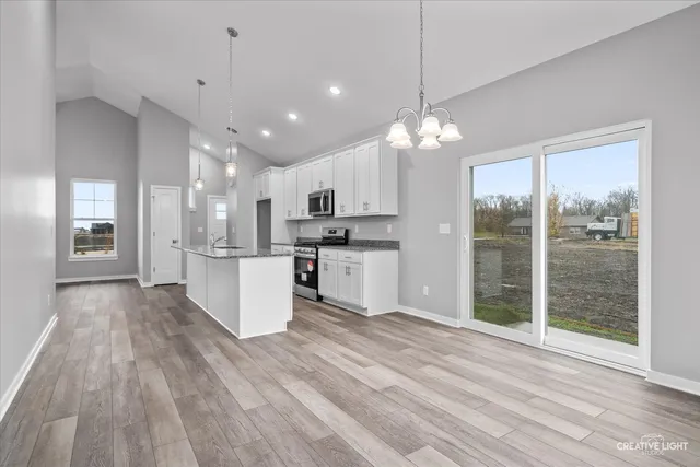 a view of kitchen with granite countertop cabinets and refrigerator