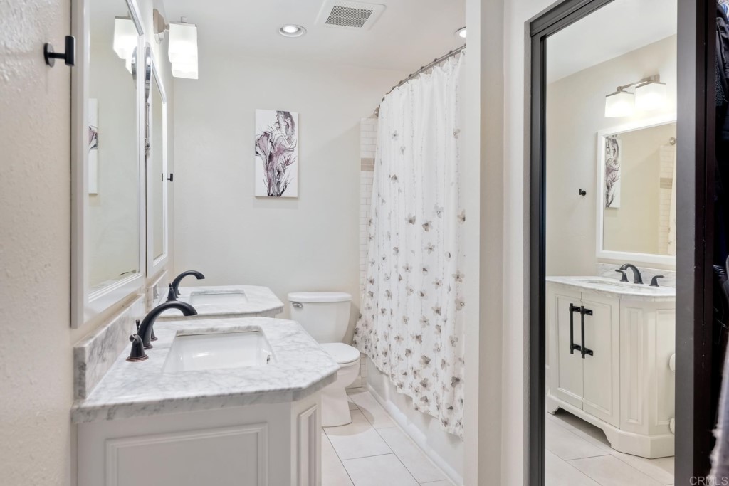 2425-27 Torrejon Place Carlsbad, CA 92009 - Photo 38 of 61 a bathroom with a sink a mirror a shower and a mirror