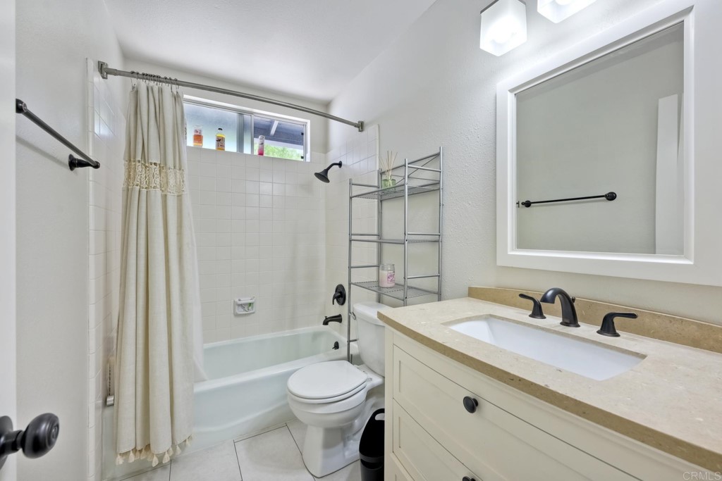 2425-27 Torrejon Place Carlsbad, CA 92009 - Photo 40 of 61 a bathroom with a granite countertop sink toilet a mirror a vanity and shower