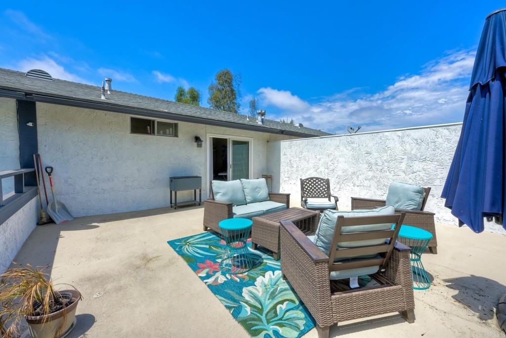 2425-27 Torrejon Place Carlsbad, CA 92009 - Photo 42 of 61 a view of a patio with couches chairs potted plants and wooden floor