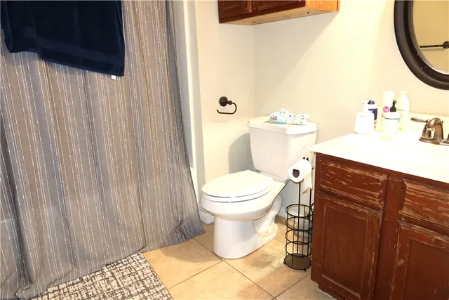 a bathroom with a sink a toilet and shower curtain