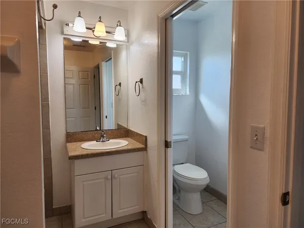 a bathroom with a granite countertop sink toilet a mirror and shower