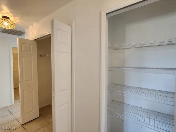 a view of walk in closet with empty racks