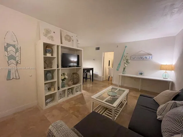a living room with furniture a rug and a flat screen tv