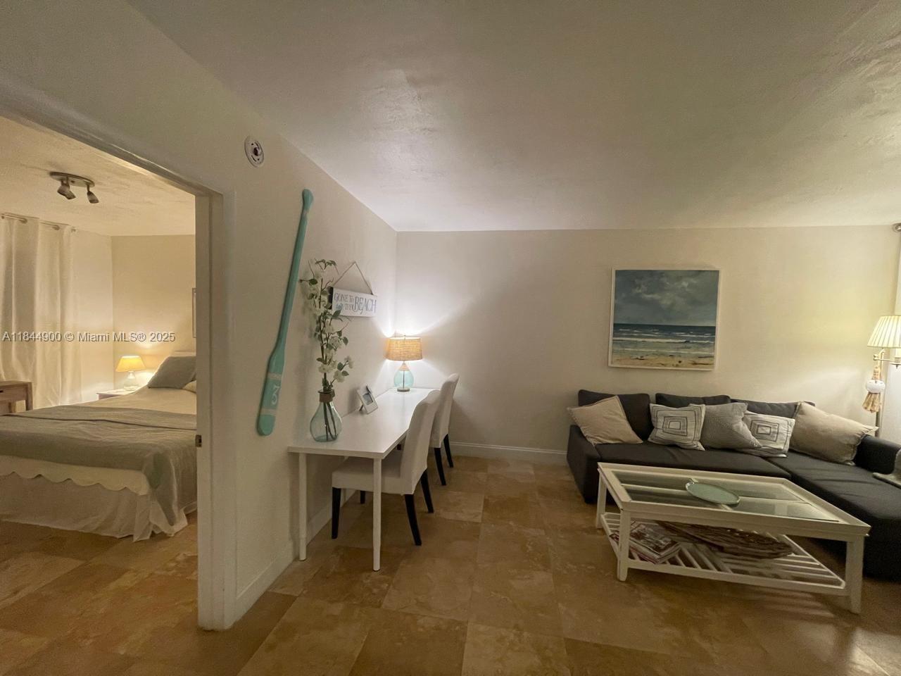 100 Sunrise Drive, Unit 27 Key Biscayne, FL 33149 - Photo 5 of 24 a living room with furniture and a chandelier