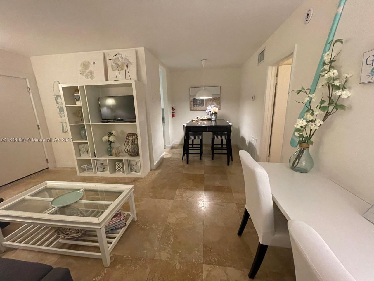 100 Sunrise Drive, Unit 27 Key Biscayne, FL 33149 - Photo 7 of 24 a room with furniture and a table
