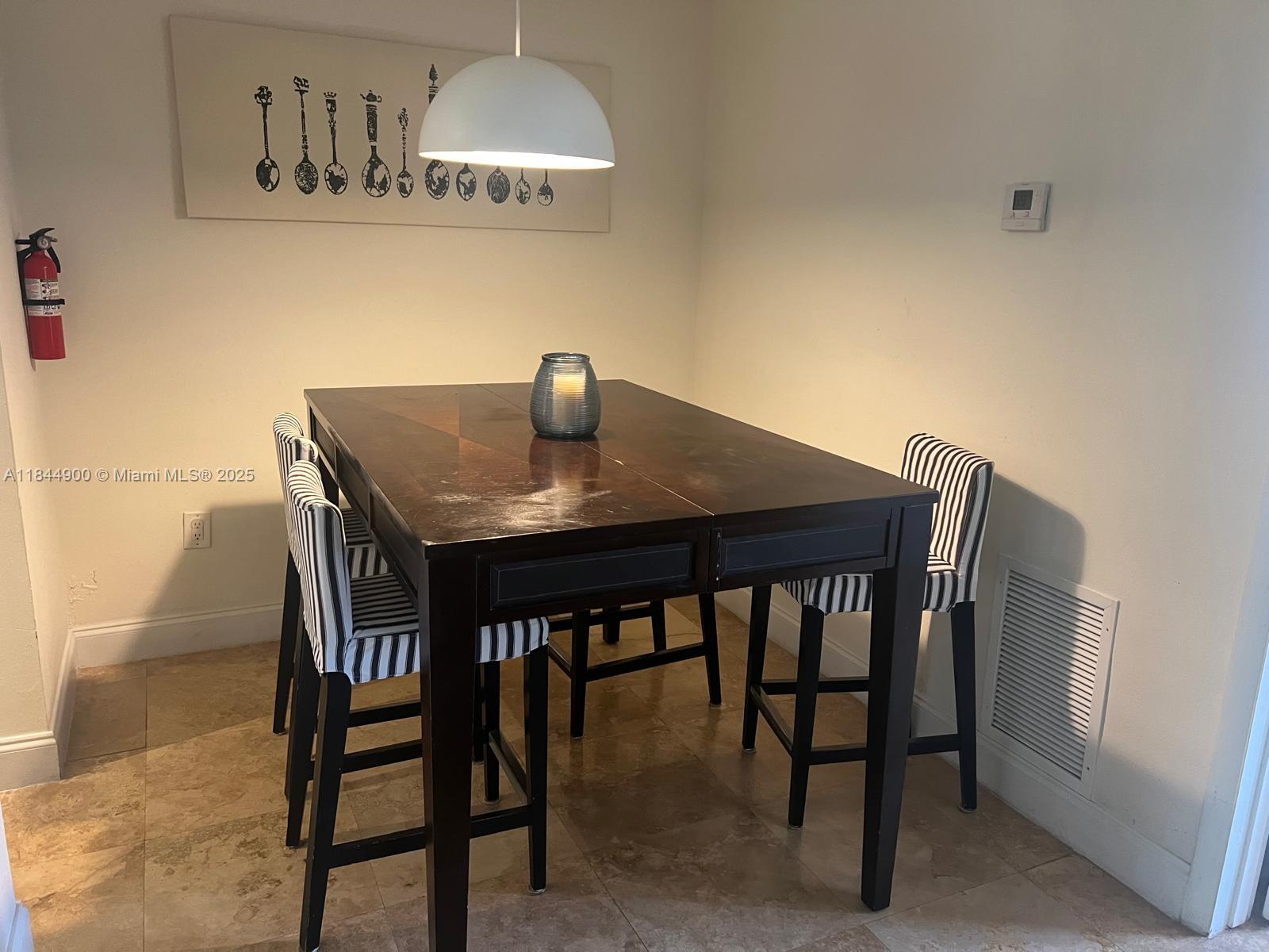 100 Sunrise Drive, Unit 27 Key Biscayne, FL 33149 - Photo 9 of 24 a view of a dining room with furniture and chandelier