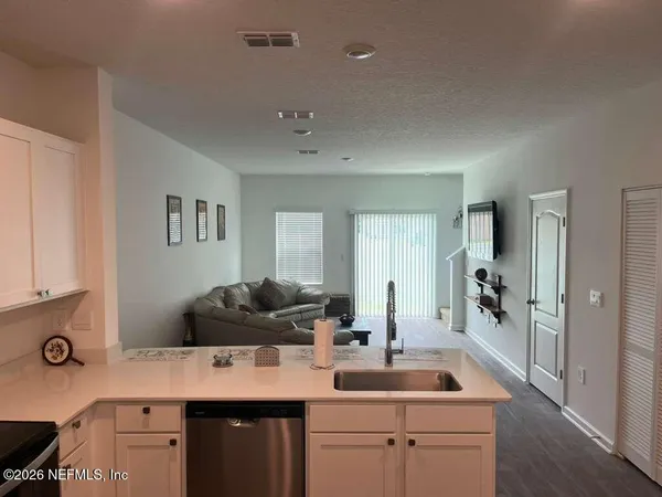a kitchen with a sink dishwasher and white cabinets