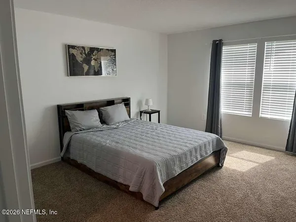 a large bed sitting in a bedroom next to a window
