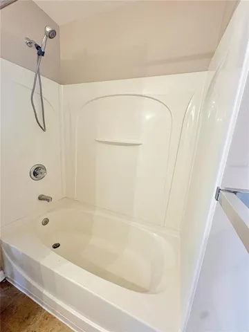 a bathroom with a bath tub with a shower