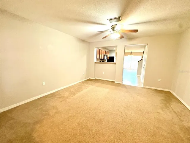 a view of a big room with windows and chandelier fan